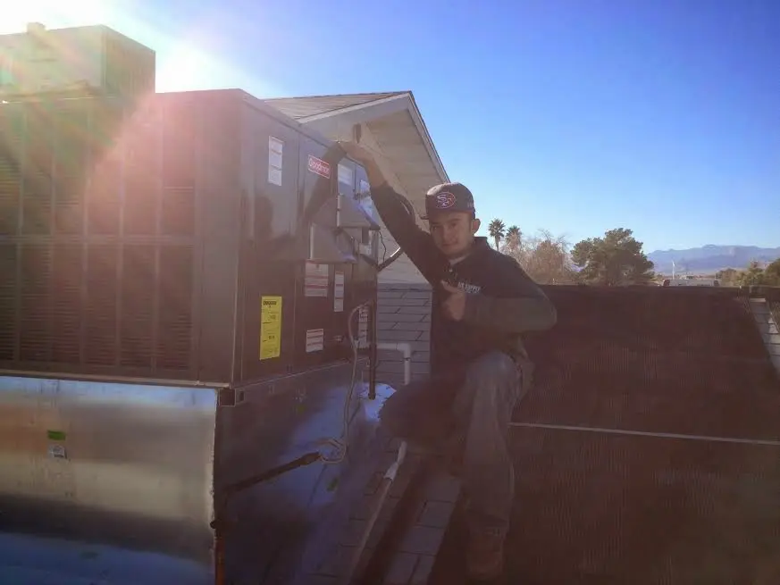 HVAC technician performing Air Duct Repair on a rooftop unit in Sartell